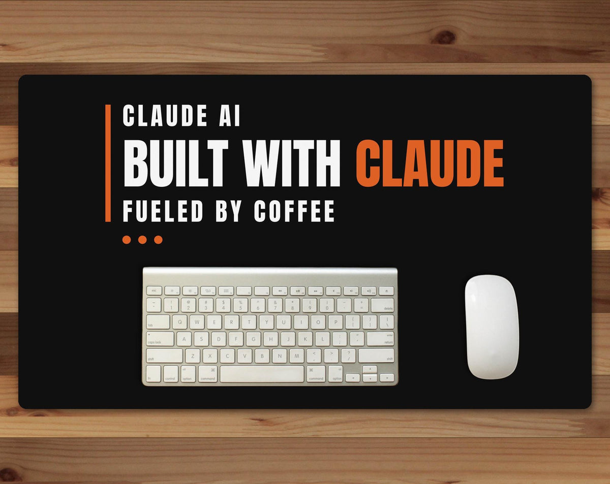 Black 24 x 14 inch desk mat that reads "Claude AI / Built with Claude, fueled by coffee", on a wood desk with a keyboard and mouse below the joke